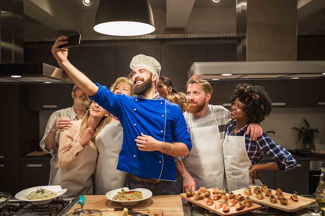 Kokk tar selfie med kursdeltakere