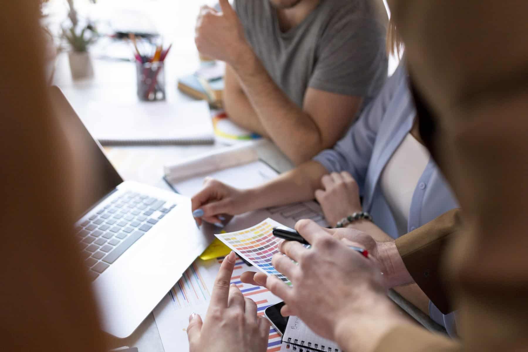 People discuss marketing strategy in front of computer.