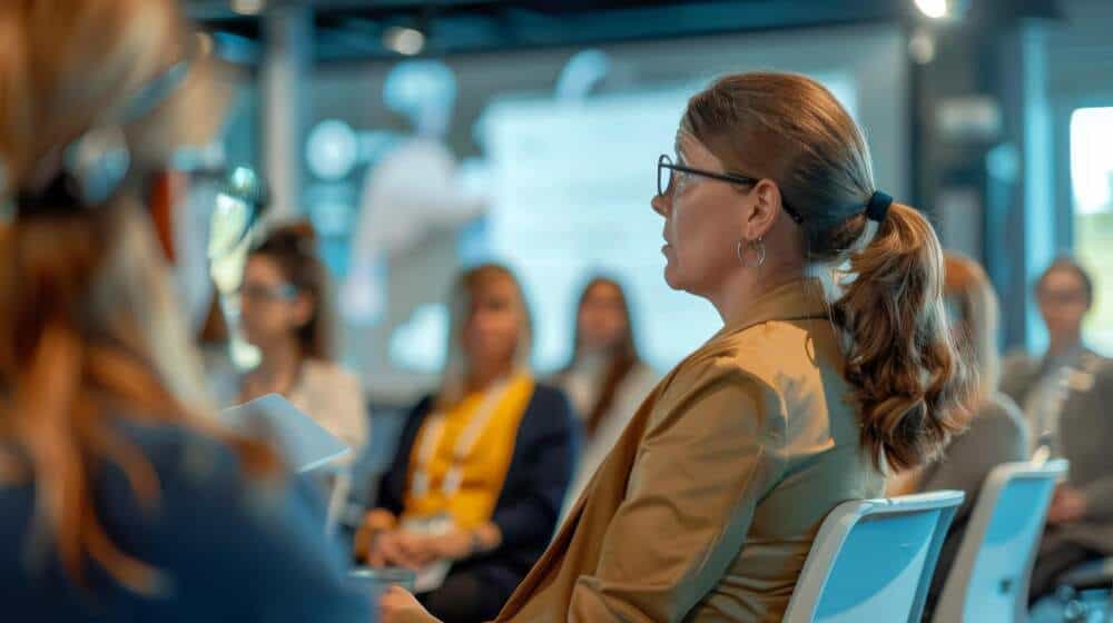 Woman sitting and listening to a presentation.